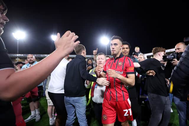 Walsall fans celebrate their League Two play-off semi-final victory over Chesterfield on the pitch at the Bescot Stadium
