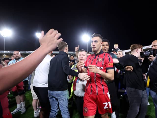 Walsall fans celebrate their League Two play-off semi-final victory over Chesterfield on the pitch at the Bescot Stadium