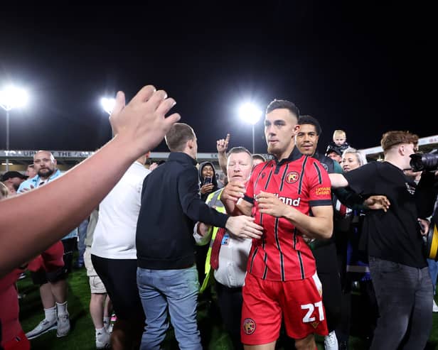 Walsall fans celebrate their League Two play-off semi-final victory over Chesterfield on the pitch at the Bescot Stadium