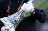 A UEFA official carrying the Europa Cup Trophy 