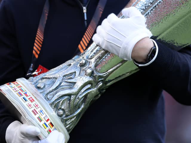 A UEFA official carrying the Europa Cup Trophy 