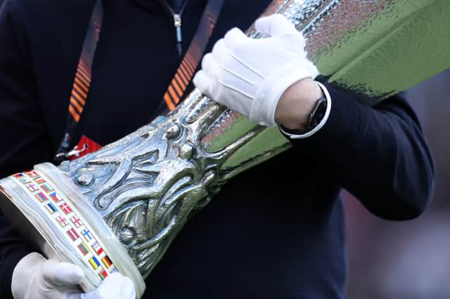 A UEFA official carrying the Europa Cup Trophy