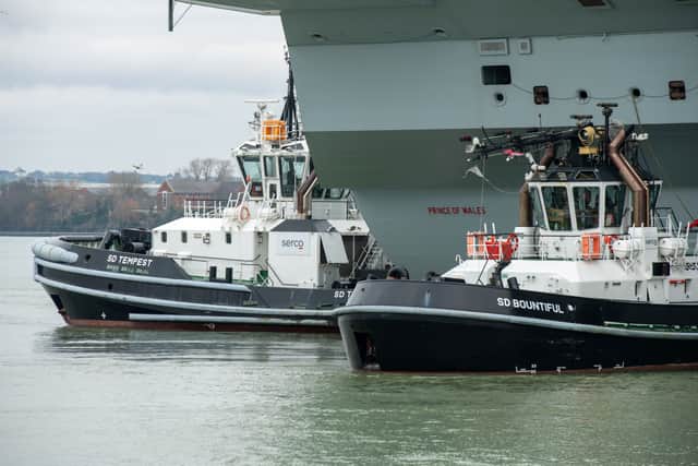 Tug boats alongside a Royal Navy ship. Many are due to be replaced with newer vessels under the fresh contract.