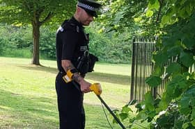 Officer with metal detector searching for knives and weapons