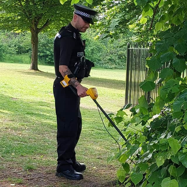 Officer with metal detector searching for knives and weapons