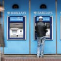 A man uses a cashpoint machine at a Barclays Bank 