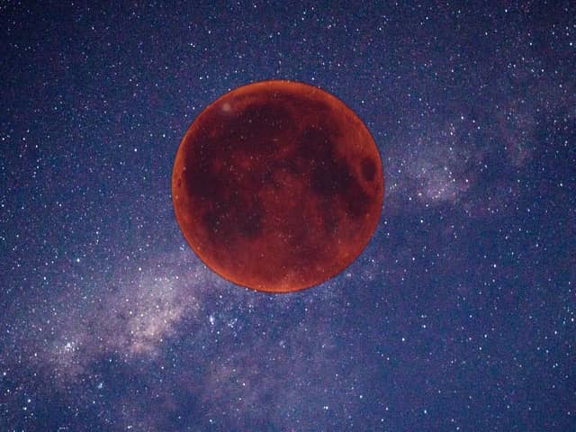 Digitally created image of a red Moon in the night sky.