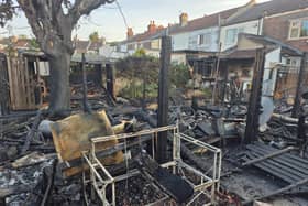 Two boys have been arrested on suspicion of arson after a large fire erupted from a tree and destroyed several garages.