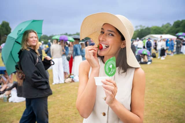 Tennis fan spotted dipping traditional strawberries into Dominos garlic and herd dip in the queue at Wimbledon