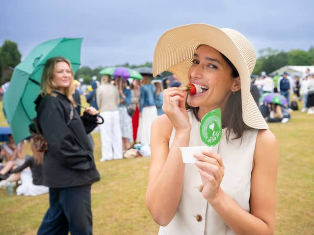 Tennis fan spotted dipping traditional strawberries into Dominos garlic and herd dip in the queue at Wimbledon