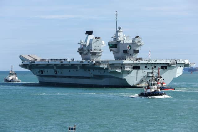 HMS Queen Elizabeth passes the Round Tower as she leaves HMNB Portsmouth.