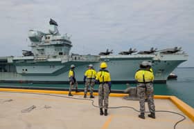 The government has issued a notice calling for stealth combat drones to be added to HMS Prince of Wales and HMS Queen Elizabeth, boosting the Royal Navy and RAF. Pictured: Members of Port Services - North wait for the arrival of the HMS Prince of Wales alongside Kuru Wharf at HMAS Coonawarra, Darwin, Northern Territory, Australia.