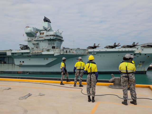 The government has issued a notice calling for stealth combat drones to be added to HMS Prince of Wales and HMS Queen Elizabeth, boosting the Royal Navy and RAF. Pictured: Members of Port Services - North wait for the arrival of the HMS Prince of Wales alongside Kuru Wharf at HMAS Coonawarra, Darwin, Northern Territory, Australia.