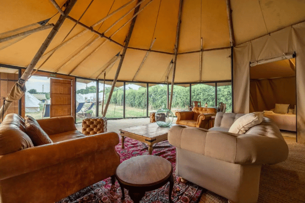 The Tipi Tenthouse Suite can house up to 10 guests, includes an En-suite shower room with flushing toilet and basin, king or twin beds and a large furnished living and dining area - everything you'd need for Glastonbury.