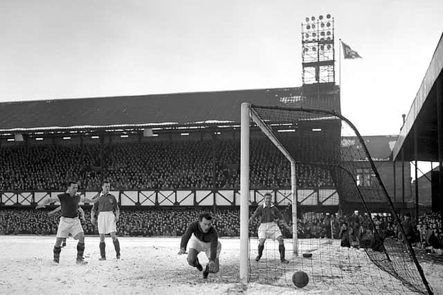 Portsmouth take on Scunthorpe United at a snowy Fratton Park in February 1954 in an FA Cup match. The historic South Stand now has floodlights attached to its rood. Fratton Park staged the first-ever floodlit Football League match in England in February 1956 against Newcastle United. / PA Archive
