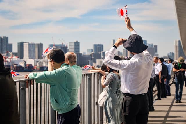 Onlookers line up to see off HMS Prince of Wales from Tokyo