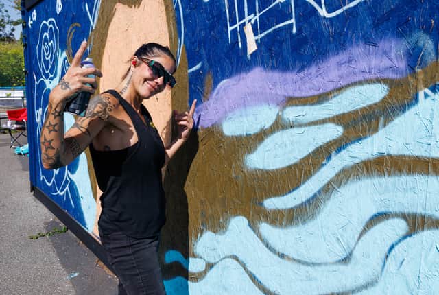 Pictured: Claudia La Bianca painting at Look Up Street Art Festival in 2025.