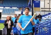Portsmouth FC fan Daniel O'Brien carries the baton through Fratton Park.