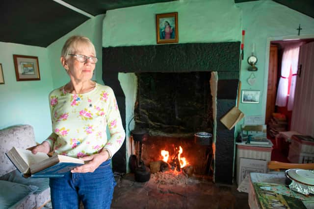 Margaret Gallagher, 77, poses in front of the open fireplace in her three roomed thatched cottage near the village of Belcoo, Enniskillen, Northern Ireland, in 2019. Most payments for winter heating/fuel and cold weather support are automatic if you already receive a qualifying benefit (Photo: PAUL FAITH/AFP via Getty Images)
