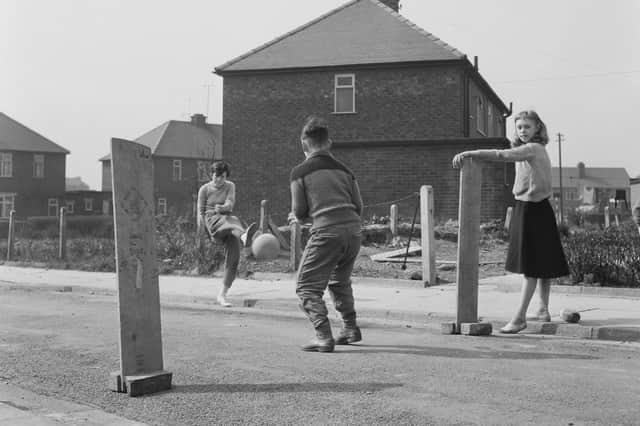 Children playing football on the street in 1960