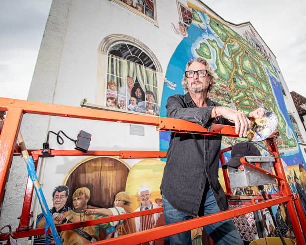 Artist Mark Lewis in front of his forever changing mural in Portsmouth.