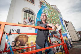 Artist Mark Lewis in front of his forever changing mural in Portsmouth.