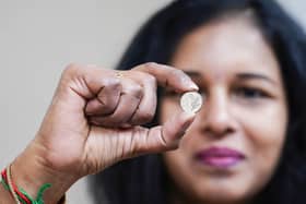 Vasanthi Balachandar, Branch Manager of Jubilee Oak Post Office, displays the first 5p coins bearing the portrait of King Charles III. Around 23.2 million coins have been minted, marking the first 5p design change in 17 years (Photo: Ian West/Royal Mint)
