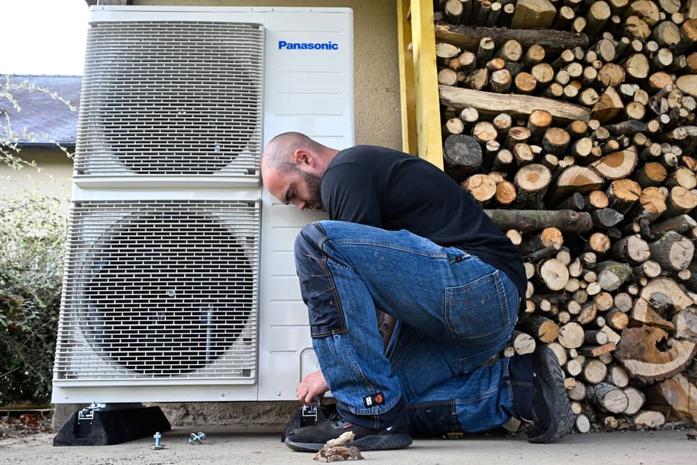 A worker installs a heat pump in a private home in western France. The Government has expanded the Boiler Upgrade Scheme to include air-to-air heat pumps that heat in winter and cool in summer (Photo: DAMIEN MEYER/AFP via Getty Images)