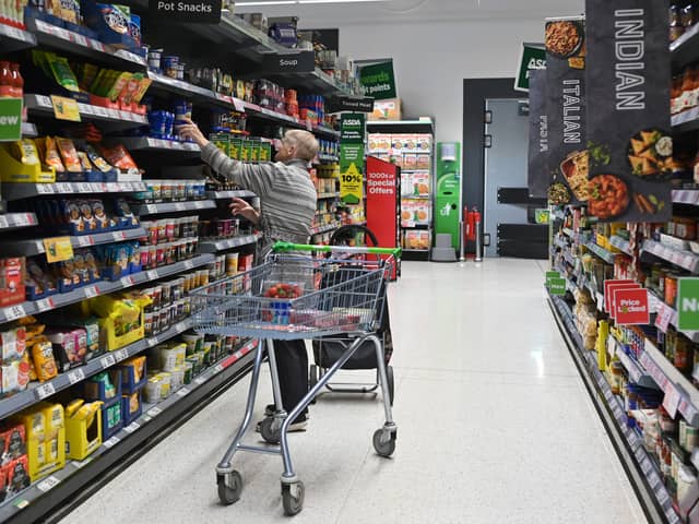 A customer looks at some goods at an Asda supermarket. The supermarket is selling 24 stores and a distribution depot in a £568m deal to boost finances (Photo: JUSTIN TALLIS/AFP via Getty Images)