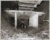 Workers standing in the bottom section of the Queensway Tunnel, Liverpool, in September 1929, beneath an experimental length of reinforced concrete, which would form the roadway.