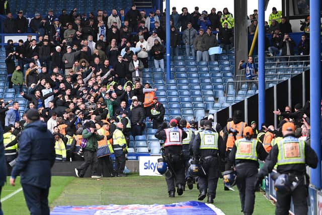 A seat is thrown at the Portsmouth fans by the Southampton fans with police moving in to clear the stadium