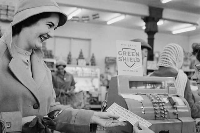 A shopper is handed a sheet of Green Shield stamps at the checkout in 1960