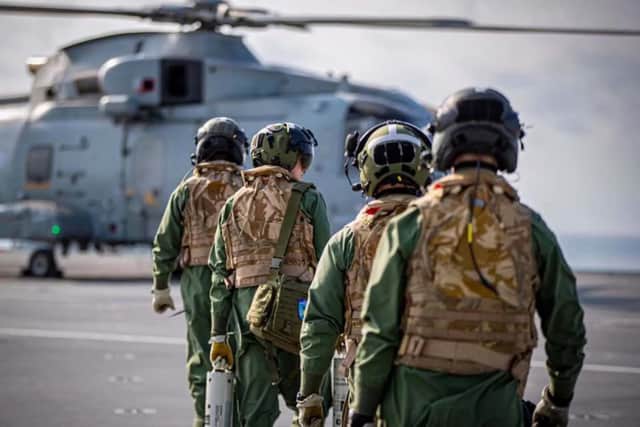 Royal Navy helicopter pilots have been bolstered with a technology contract to track submarines. Pictured: Aircrew with sonobuoys walk out to a Merlin Mk2 helicopter