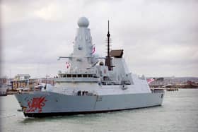 HMS Dragon sounds the horn as passes the Round Tower in Old Portsmouth.