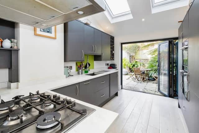The impressive 19ft kitchen features sleek fittings and bi-fold doors opening onto the garden