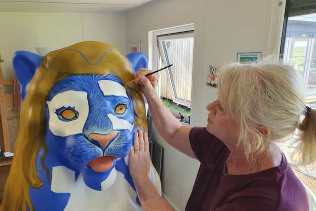 Artist Andrea Martin works on The Town Crier as part of this summer's Pride of Portsmouth lion trail.