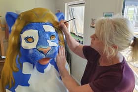Artist Andrea Martin works on The Town Crier as part of this summer's Pride of Portsmouth lion trail.