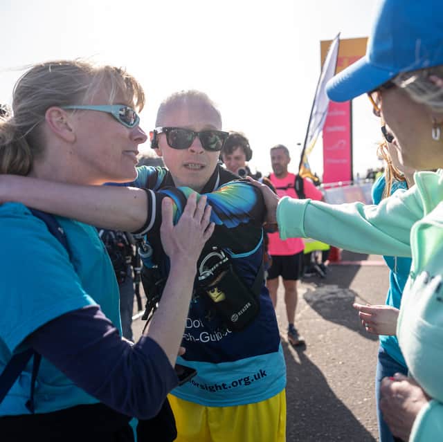 Blind artist Clarke Reynolds at the finish line of the Brighton Marathon.