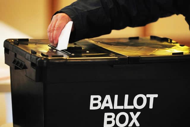 A voter places a ballot paper in the ballot box at the polling station