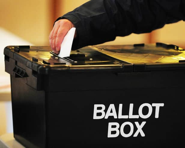 A voter places a ballot paper in the ballot box at the polling station