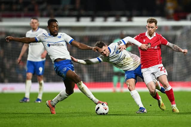 Wrexham's Lewis O'Brien battling Adrian Segecic and Ebou Adams.