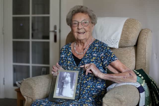 Betty Cowley, who turns 104 today, at her home in Southsea with a framed wedding picture of her and her husband when they married in 1944 