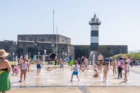 People enjoying the bank holiday sun in Southsea at the water fountains in front of Southsea Castle . Pictured by Alec Chapman