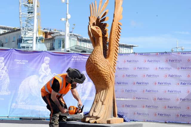Sculptor Chris Bain with the Phoenix at the live-carving event on Saturday, April 18.