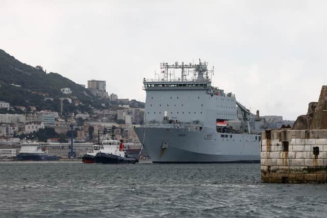 RFA Lyme Bay departing Gibraltar dock escorted by a tug.
