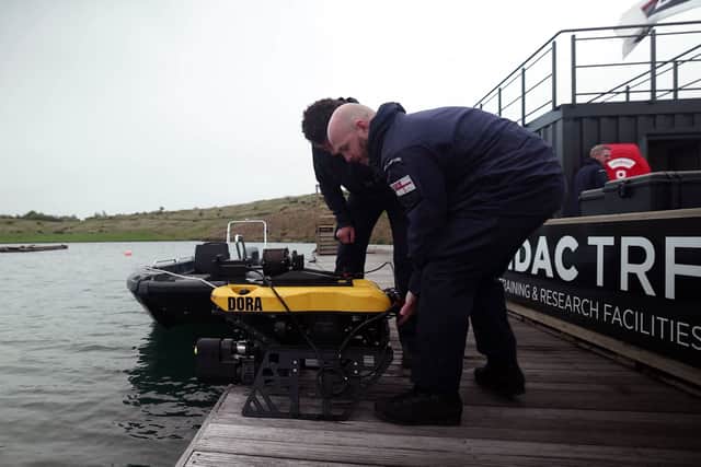 Two divers prepare to launch Defender on a practice run. A remote-controlled robot designed to destroy mines has been thoroughly tested by Royal Navy divers before being prepared for the Middle East.