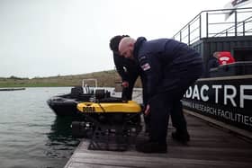 Two divers prepare to launch Defender on a practice run