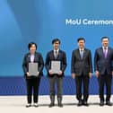 John Lee (centre) witnesses the exchange of memoranda between organisations from both sides.