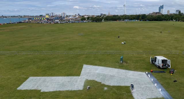 Workers start to create the Portsmouth100 logo on Southsea Common
