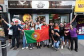 Portugal supporters outside Cafe Prazeres during Portugal's opening game of the World Cup on Wednesday, June 17. Janete Bichinho, Pedro Bichinho and Daniel De Freitas are holding the Portuguese flag.